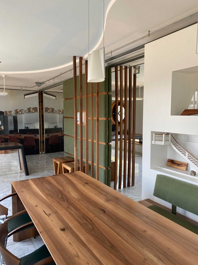 Eleganter Besprechungstisch mit maßgefertigter Tischplatte aus Holz und schöner Tischbank sowie Sesseln.
