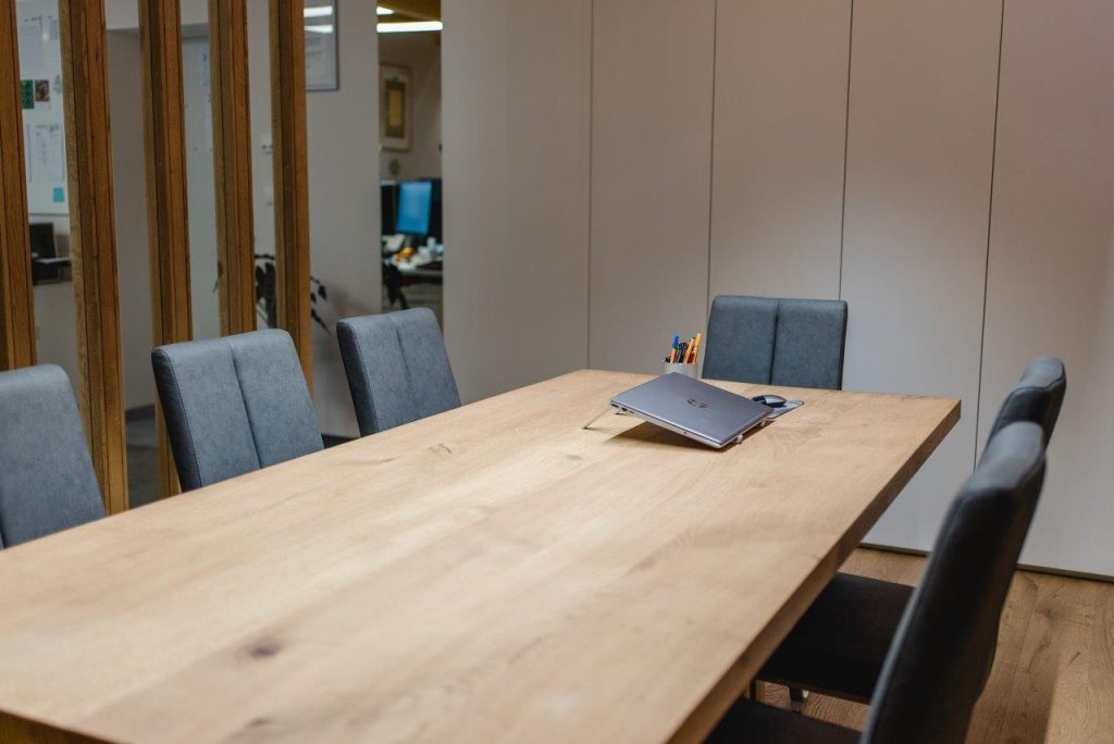 Besprechungstisch mit maßgefertigter Tischplatte aus Holz und eleganten Sesseln.