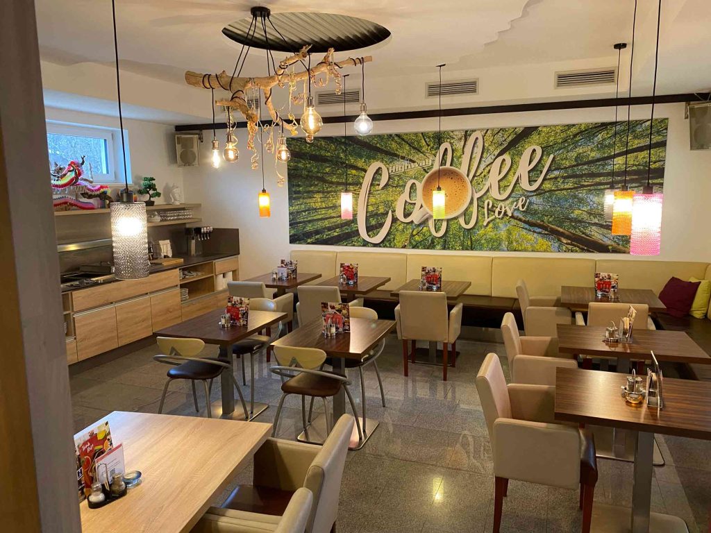 Rustikale Gastromöbel mit Tisch und Stühlen aus Holz in einem Cafe.